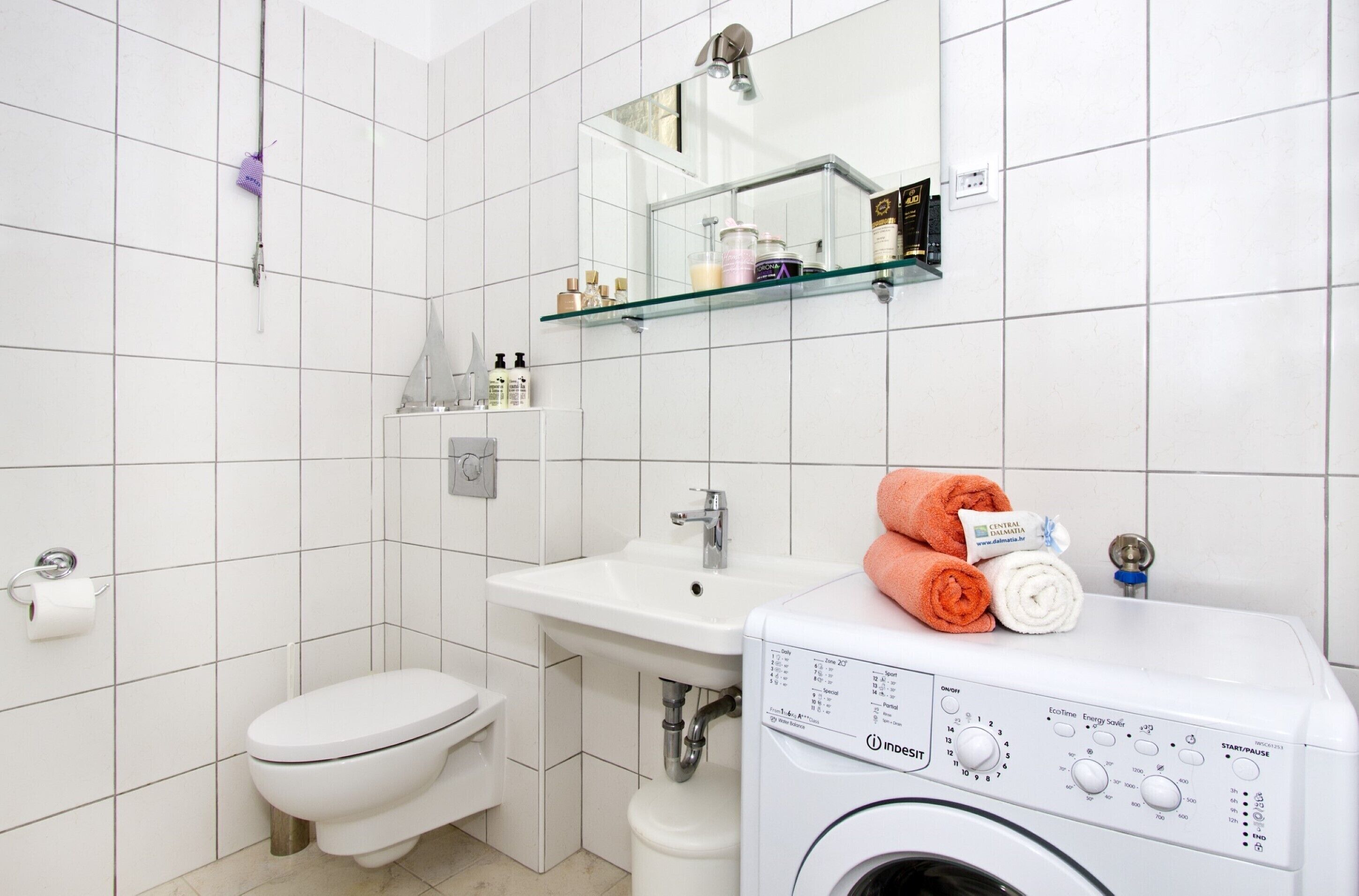Ein modernes Badezimmer mit Toilette, Waschbecken und Waschmaschine.