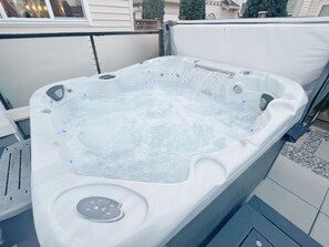 Un bain à remous avec de l’eau en circulation, entouré d’une terrasse.