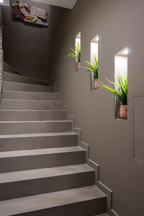 A staircase with a modern design, flanked by wall-mounted planters with green plants.