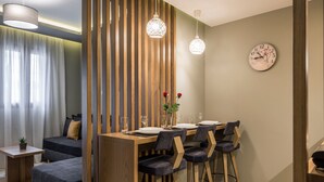Un'area pranzo moderna con un tavolo in legno, sedie scure e lampade a sospensione.