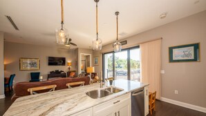 A modern kitchen with a marble countertop, stainless steel sink, and pendant lights. - Downtown Dunedin Walking District (Dunedin)