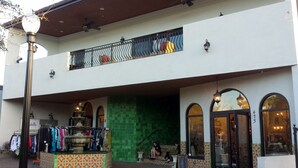 A two-story building with a green-tiled entrance, a balcony with metal railings, and a signboard outside. - Downtown Dunedin Walking District (Dunedin)