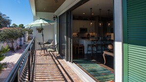 A balcony with a wooden floor, outdoor furniture, and a green awning. - Downtown Dunedin Walking District (Dunedin)
