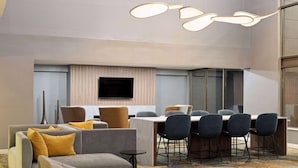 Ein moderner Konferenzraum mit einem großen Tisch, mehreren Stühlen und Sofas.