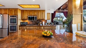 Una cocina moderna con armarios de madera, electrodomésticos de acero inoxidable y encimera de mármol.