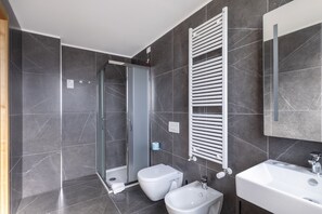 Een douche, een haardroger, een bidet, handdoeken