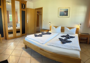 Une chambre d’hôtel avec un grand lit, une armoire et un miroir.