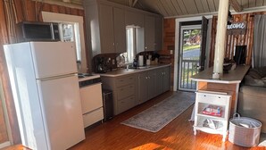 Une cuisine avec des meubles de rangement en bois, un réfrigérateur et un évier.