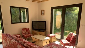 Un salon comprenant un canapé, un téléviseur et une table basse en bois.