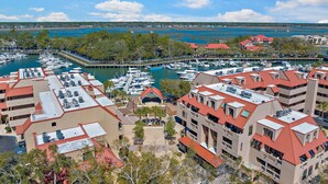 A marina with boats docked, surrounded by buildings with red roofs and a view of a lake. - Water & Marina Views, Pet Friendly-Near Beach (Hilton Head Island)