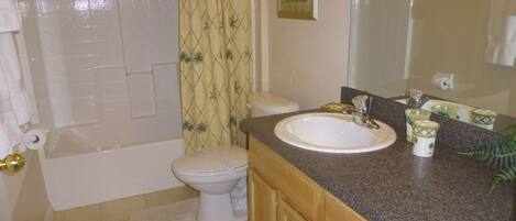 A bathroom with a bathtub, toilet, and sink.