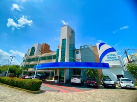 Un hotel con diseño moderno, que destaca por su entrada principal y un toldo azul.