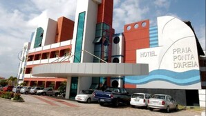 A hotel with a modern architectural design, featuring a prominent wave-like structure on the facade. - Hotel Praia Ponta D'areia (São Luís)