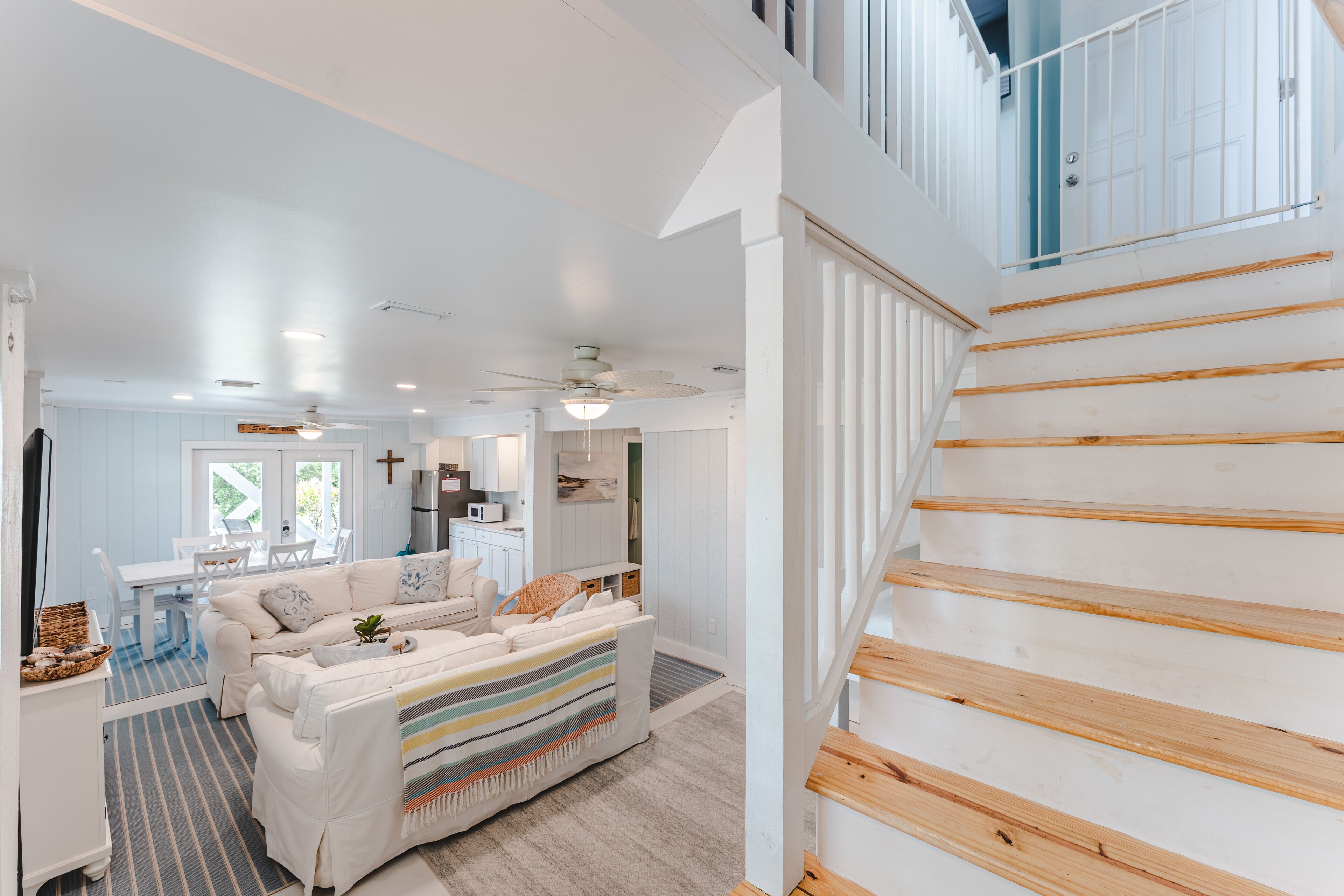 A spacious living area with a staircase, a dining area, and a kitchen.