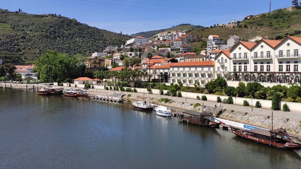 A riverside town with a hotel named "The Authentic Stage House Hotel" along the water. - Alojamento 2 Dos Santos (Pinhão)