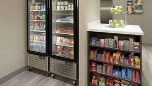 Un kiosque proposant une variété de collations emballées, ainsi qu’un espace réfrigéré où sont conservées des boissons et des produits laitiers.