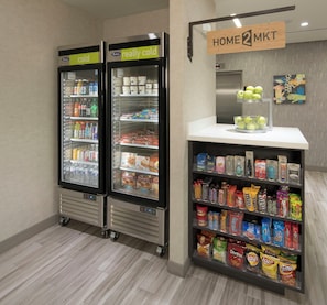 A self-service kiosk with a variety of snacks and beverages, including chips and bottled drinks. - Home2 Suites by Hilton Owasso (Owasso)