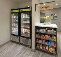 Un quiosco autoservicio con una variedad de aperitivos y bebidas, como papas fritas y bebidas embotelladas.