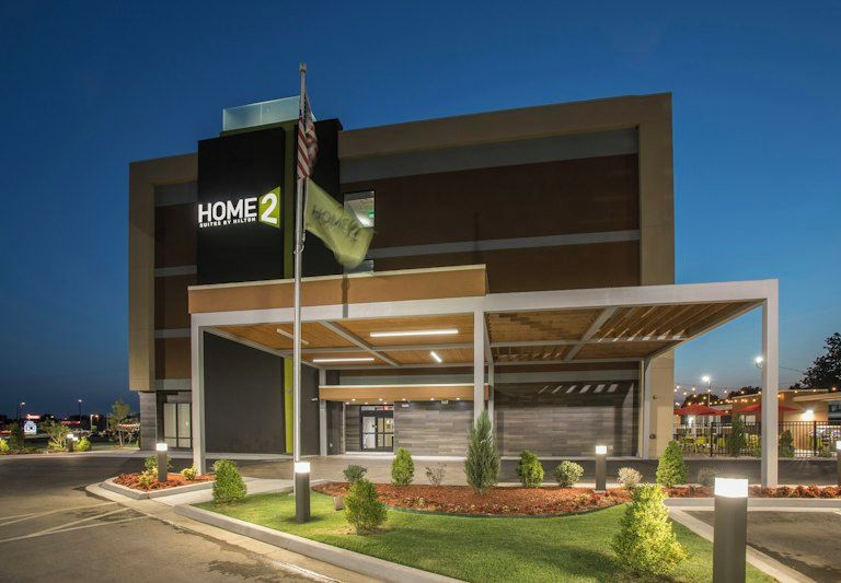 A modern building with a covered entrance and a flagpole.