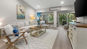 A spacious living room with a white sofa, wooden coffee table, and a ceiling fan. - 1 BR/1.5 BA Villa! Amenity access included. NO pets (Seabrook Island)