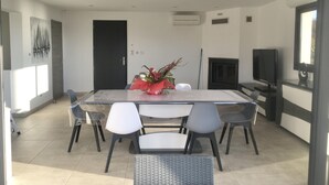 A modern dining area with a glass table, white chairs, and a decorative centerpiece.