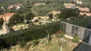 A view of a rural landscape with houses, trees, and a fenced area.