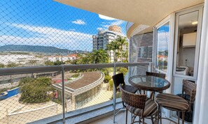 Un balcón con vistas a un paisaje urbano, que incluye edificios y una montaña.