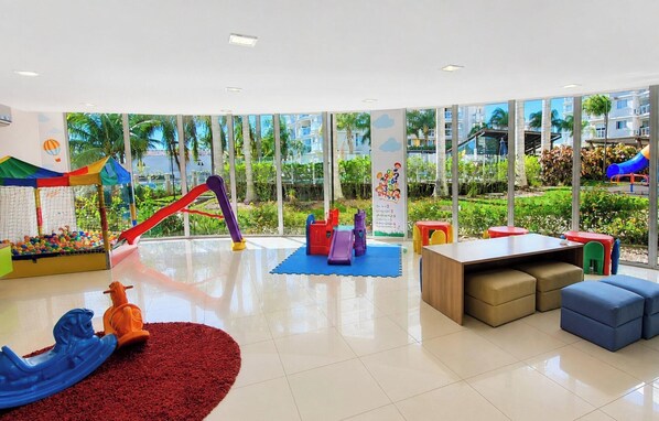 Un espace de jeux pour enfants avec une piscine à balles, des toboggans et du mobilier en mousse.