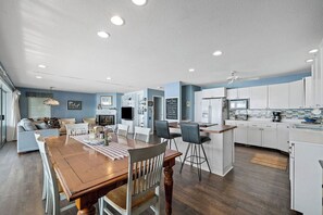 A modern kitchen with white cabinets, a wooden dining table, and a built-in island. - Your own private  Lake Michigan sunset from SouthHavenKing (South Haven)