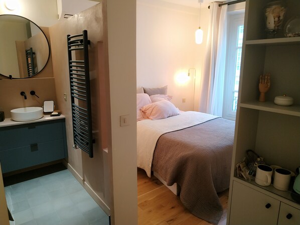 A bathroom with a round mirror, a towel rack, and a sink with a white basin.
