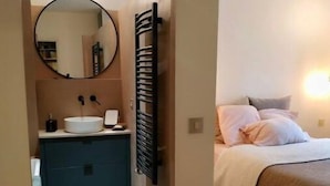 A bedroom with a bed, a bedside table, and a nightstand.
