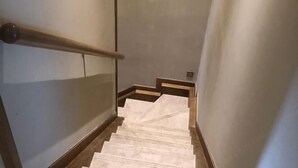 Eine Treppe mit Handlauf und einer hellen Wand.