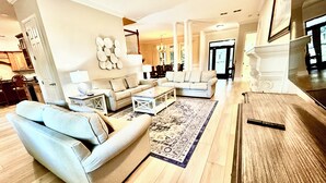 A spacious living room with two sofas, a coffee table, and a patterned rug.