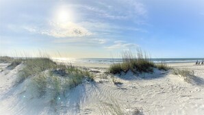 A beach with sand dunes and a clear sky.