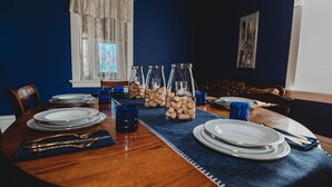 Une table à manger dressée avec des assiettes, des couverts et des bocaux en verre contenant des bouchons.