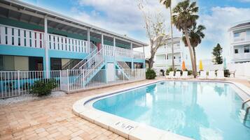 A swimming pool with a 6 1/2 ft depth, a covered deck with stairs, and a white fence.