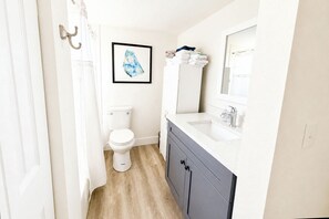 A modern bathroom with a toilet, sink, and mirror.