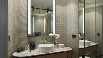 A modern bathroom with a curved shower, a large mirror, and a round sink.