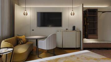 A modern hotel room with a sofa, a round table, a TV, a coffee machine, and a small cabinet.