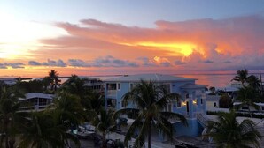 Un edificio sul lungomare con vista sul tramonto sull'oceano.