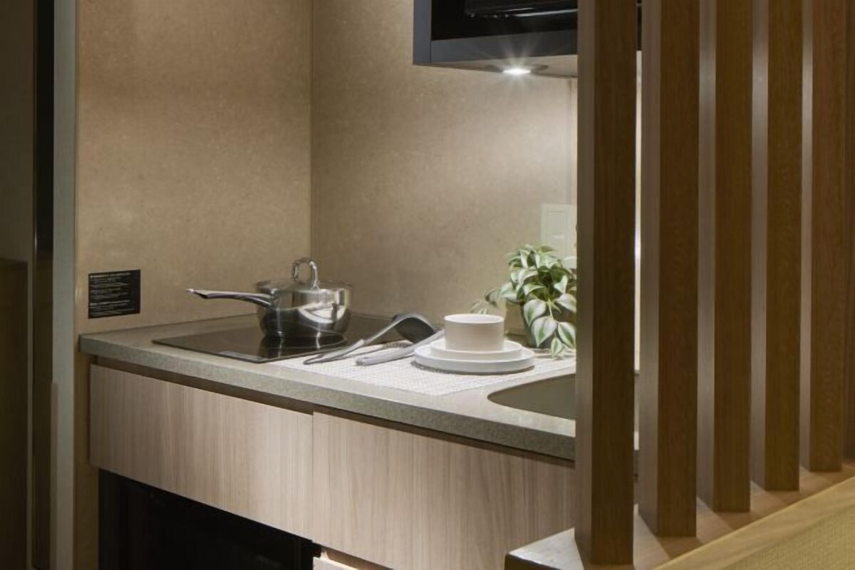 A modern bathroom with a sink, mirror, and a potted plant.
