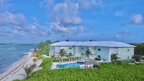A beachfront property with a swimming pool, palm trees, and a view of the ocean. - BEACH and POOL at Rum Point - North Side in most secluded and tranquil area (North Side)