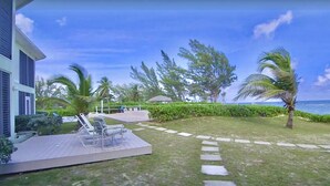 A resort with a pool area, lounge chairs, and a view of the ocean. - BEACH and POOL at Rum Point - North Side in most secluded and tranquil area (North Side)
