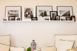 A wall with a series of framed photographs and a decorative vase. - Amalfi Coast Luxury Villa with Swimming Pool (Praiano)