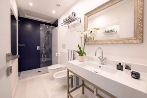 A modern bathroom with a large mirror, a white sink, and a shower area. - Luxury Suite with Garden and Jacuzzi (Sant'Agnello)