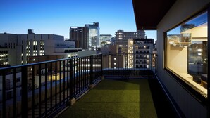 A balcony with a view of a cityscape at dusk.