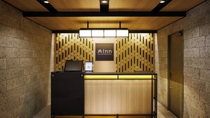 A reception desk with a wooden finish and a sign that reads "Minn your second home."