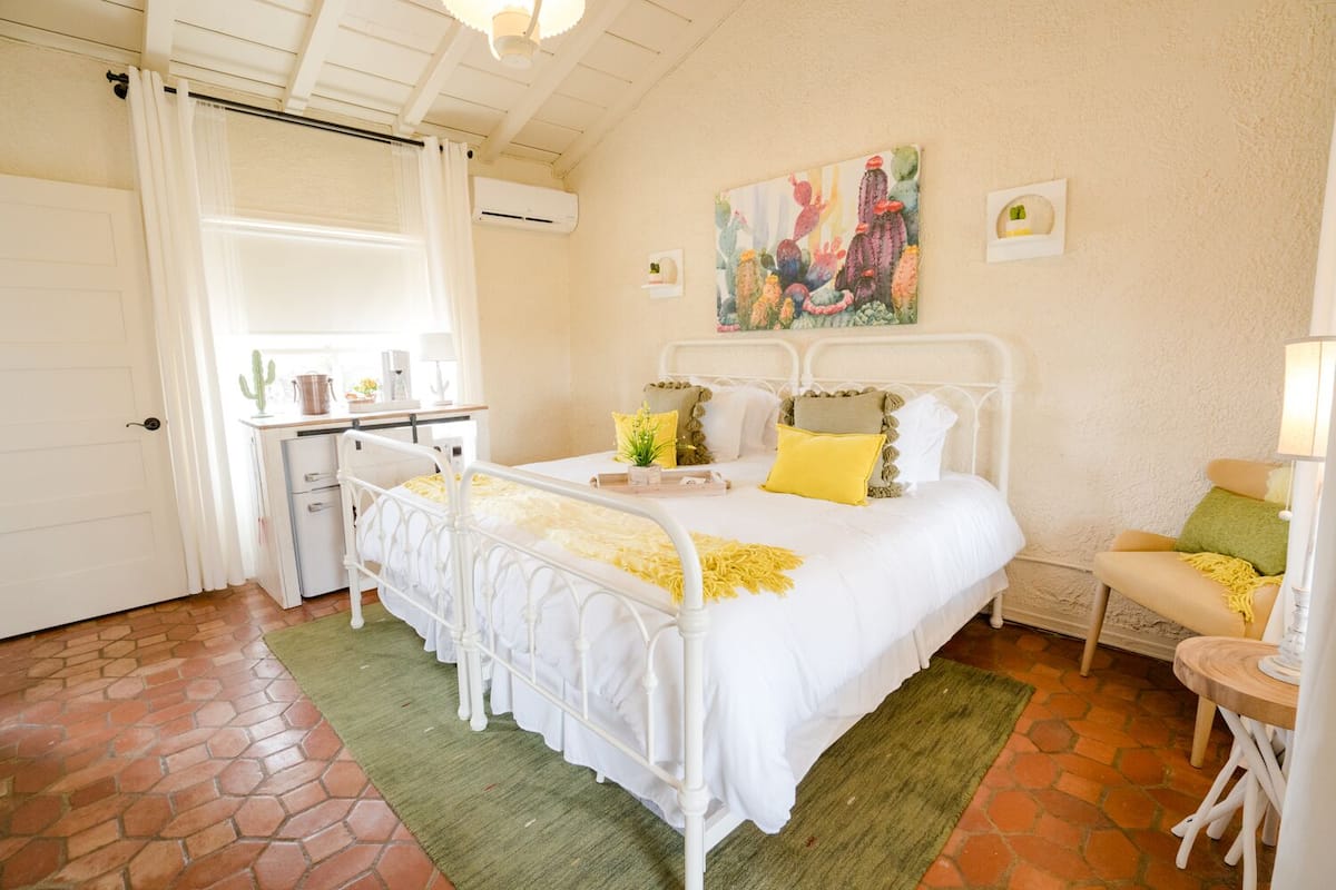 Un dormitorio con cama, mesita de noche y un cuadro en la pared.
