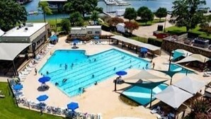 Vista aerea di un resort con una grande piscina, lettini e uno scivolo acquatico.