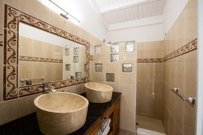 Chuveiro, secador de cabelo, toalhas de banho, papel higiênico